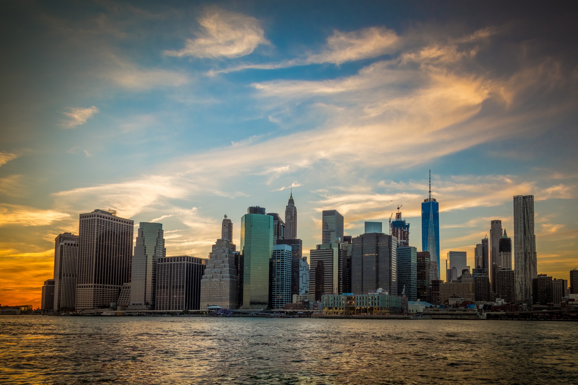 Manhattan skyline overlooking the waterfront at sunset